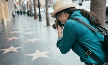 turista fotografando as estrelas na Calçada da Fama em Hollywood durante viagem aos Estados Unidos