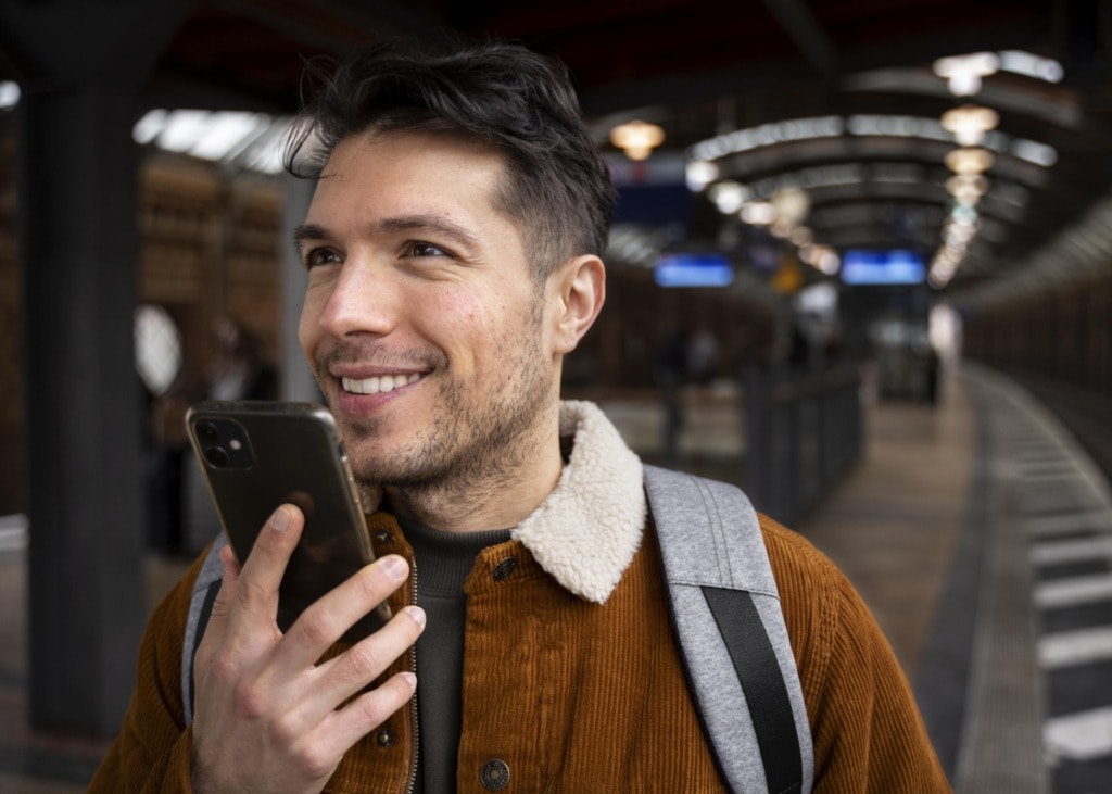 close up smiley man holding device min
