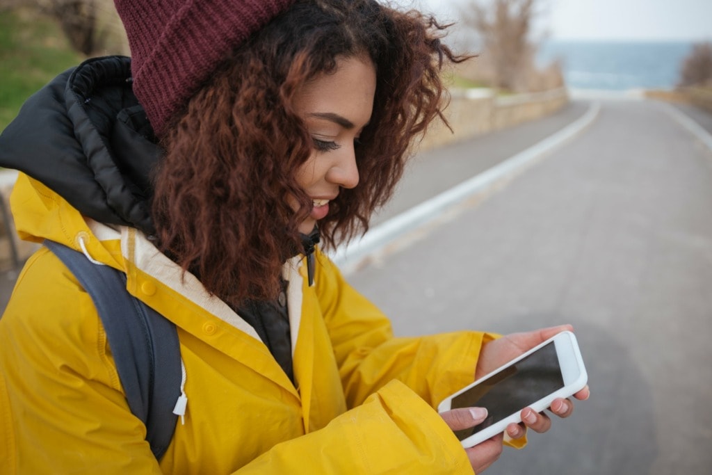 woman near road using smartphone min