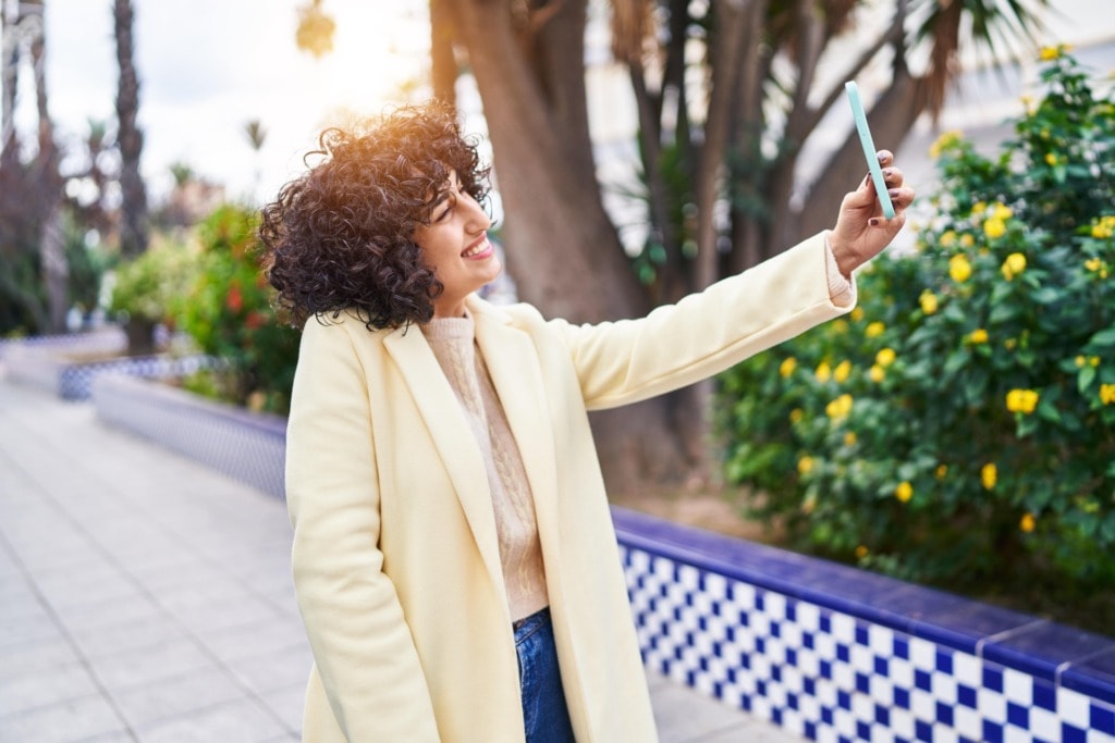 young middle east woman excutive smiling confident make selfie by smartphone park min